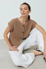 Cardigan tostado de tejido de punto acanalado, con escote en V, manga corta y cierre frontal con botones.