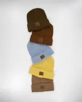 Gorro de lana celeste tejido en punto con dobladillo y parche de cuero con logo en el frente.