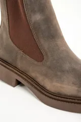 Bota marrón de cuero con elástico lateral y suela de goma.