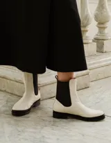Bota Chelsea color crema de cuero vacuno, con elástico lateral negro, suela de cuero y taco de 2,5 cm. Hecha a mano en Argentina.