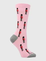 Calcetines largos de algodón color rosa pálido con estampado repetitivo de guardias reales británicos en uniforme rojo y negro. El talón y la punta son de color gris.
