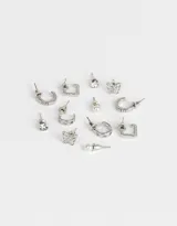 Set de seis pares de aros dorados con diferentes diseños: aros tipo argolla con strass, aros tipo argolla con calados, aros con forma de mariposa, aros con perlas y aros con strass.