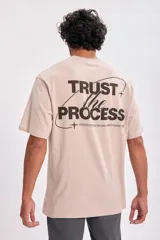 Remera color beige de corte oversize con estampa en la espalda con la frase "Trust the process".