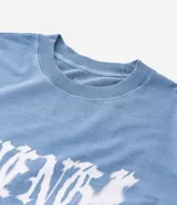Remera masculina de algodón color azul, con corte boxy, cuello redondo y mangas cortas. Presenta una estampa frontal con la palabra "Revenge" en tipografía gótica.