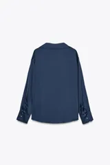Camisa azul marino de satén con cuello solapa, escote en pico y mangas largas con puños abotonados.