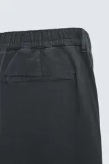 Pantalón negro de corte recto, confeccionado en tejido de mezcla de algodón y lino. Presenta cintura elástica, bolsillos laterales y traseros.
