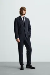 Pantalón de vestir color verde oliva, corte slim fit, con bolsillos laterales y traseros de ojal con botón. Cierre frontal con cremallera y botón.