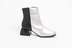 Botas cortas de cuero plateado y negro con punta cuadrada y taco geométrico.