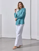 Camisa blanca de lyocell, marca Dash. Tiene cuello con solapa, abertura central con botones, mangas largas regulables con presilla y botón, y dos bolsillos delanteros aplicados.
