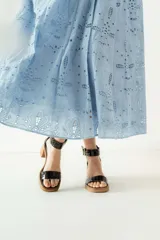 Sandalias de cuero color crudo, con tira ancha sobre los dedos, pulsera con hebilla al tobillo y taco cuadrado de madera.