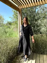 Vestido camisero amplio y largo de lino color azul, con botones de nácar, cuello camisero y bolsillos laterales.