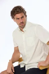 Camisa azul marino lisa de manga corta con cuello abotonado, cierre frontal con botones y bolsillo en el pecho. Confeccionada en algodón.
