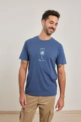 Remera azul de algodón con cuello redondo y estampado de una palmera con texto en el frente.