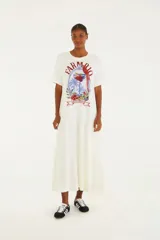 Vestido largo blanco con estampado de cóctel, palmeras y un loro. Tiene escote recto y corte fluido.