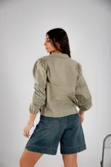 Camisa color verde oliva con detalles de encaje en el frente y en las mangas largas abullonadas.