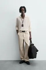 Sweater color crema de punto, con cuello polo y mangas largas. Tejido en hilatura de cáñamo con acabados en rib.