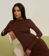Vestido midi marrón de poliéster y elastano, con cuello redondo, mangas largas, espalda descubierta, fruncido en la parte baja de la espalda y abertura en la falda.