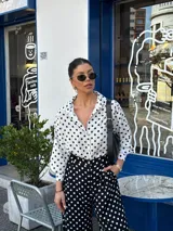 Conjunto de camisa y pantalón de viscosa con estampado de lunares blancos sobre fondo negro.