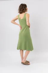 Vestido midi verde oliva de tejido acanalado, con escote en V y silueta al cuerpo con caída fluida.