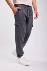 Pantalón deportivo tipo jogger color gris oscuro, con bolsillos cargo laterales, cintura elástica ajustable con cordón y puños elásticos.