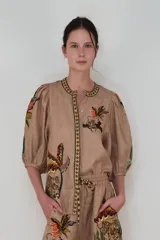 Camisa de lino color rosa pálido con estampado de tigres y palmeras en tonos tierra, corte recto y mangas abullonadas 3/4.