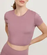 Remera deportiva cropped de poliéster y elastano, color celeste, con cuello redondo y mangas cortas.