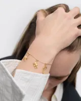 Dije dorado con forma de llave y textura efecto arena, con circonita engarzada.