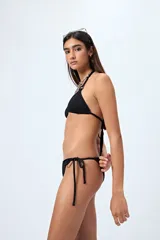 Bottom de bikini negro con textura, corte clásico y tiras laterales para ajustar.