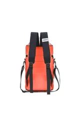 Mochila matera celeste con detalles en negro, con correas de mochila y correa larga para usar como bolso. Tiene un bolsillo frontal con cierre y un aplique circular con un corazón. Incluye un llavero naranja con la palabra 'TRENDY'.