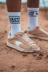 Championes color crema con suela blanca y logo blanco en el lateral.