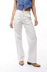 Pantalón blanco de corte recto, con bolsillos laterales y traseros. Se ajusta a la cintura con cinturón de cuero marrón.