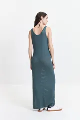 Vestido largo de punto color beige, con textura acanalada y escote redondo. De tiras finas y silueta al cuerpo, con tajo lateral.
