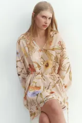 Vestido corto de viscosa con estampado floral, cuello mao fruncido y abertura en V. Tiene corte holgado, cinturón extraíble para atar en la cintura, mangas globo largas de corte raglán con abertura y botón en los puños.