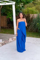 Conjunto de dos piezas color beige claro, compuesto por un top strapless con bajo asimétrico y un pantalón ancho de tiro alto.