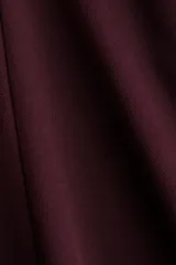 Vestido corto color borgoña, sin mangas, con escote redondo, costuras moldeadoras en el frente y la espalda, cierre oculto en la espalda y falda con vuelo.