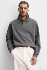 Polo manga larga gris con cuello solapa y cierre frontal de botonadura.