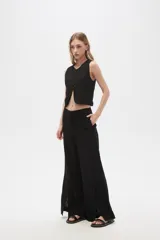 Pantalón negro ancho de lino y viscosa, de tiro alto y corte palazzo con aberturas en el ruedo.