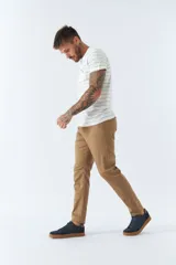 Pantalón de gabardina color beige, corte slim fit, con cinco bolsillos y logo bordado.