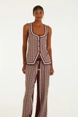 Pantalón de corte holgado y cintura alta con estampado geométrico en tonos borgoña, beige y gris.