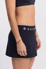 Top de bikini negro con corte halter y detalle de aro metálico en el cuello.