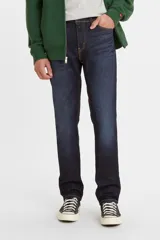 Pantalón de jean de corte slim fit, color azul oscuro, con costuras a la vista en color ocre.