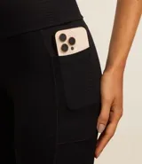 Calza legging negra de microfibra con textura y bolsillos laterales.
