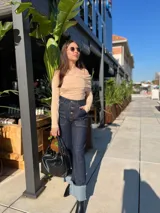 Pantalón de jean azul con bolsillos delanteros con botón y corte acampanado.