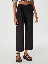 Pantalón negro de corte cropped con lazo en la cintura.