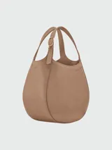 Bolso bandolera pequeño de cuero color crema, con correa ajustable y cierre superior.