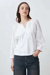 Remera blanca de mangas largas con detalle de broderie.