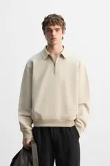 Sudadera negra de algodón con cuello polo y cierre de cremallera.