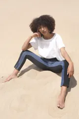 Pantalón chupín de tiro alto con cortes y combinación de colores azul denim y negro.