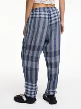 Pantalón largo a cuadros azules y grises, de pierna recta y tiro medio. Tiene pretina con elástico y bolsillos laterales.