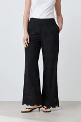 Pantalón negro de corte amplio con bordado de boderie y lazo de ajuste en la cintura.